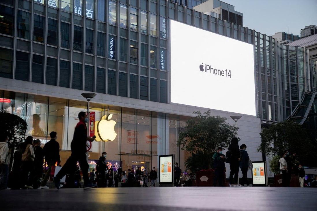 People walk near a display advertising Apple’s iPhone 14 outside its store in Shanghai on November 7, 2022. Photo: Reuters