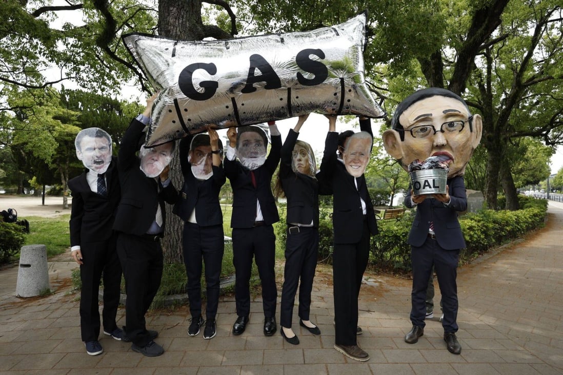 Activists dressed as G7 leaders hold a basket of “coal” and a “gas pipeline” balloon to protest against the Japanese government’s support for fossil fuels, on May 18, ahead of the G7 summit in Hiroshima. Photo: Bloomberg