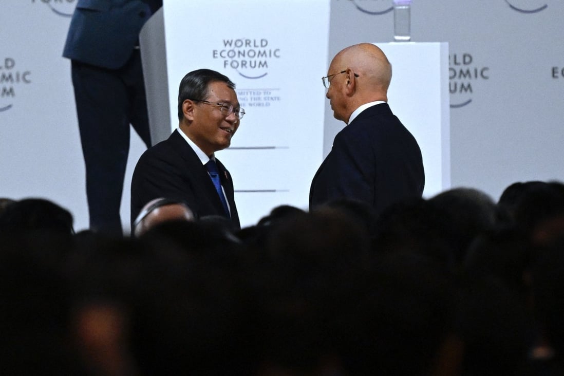 Chinese Premier Li Qiang talks with Klaus Schwab, founder and executive chairman of the World Economic Forum, after his speech during the opening ceremony. Photo: AFP