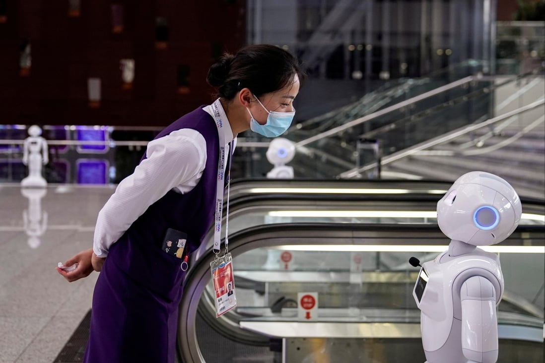 A staff member at the World Artificial Intelligence Conference looks at a robot at the venue in Shanghai on July 9, 2020. Photo: Reuters