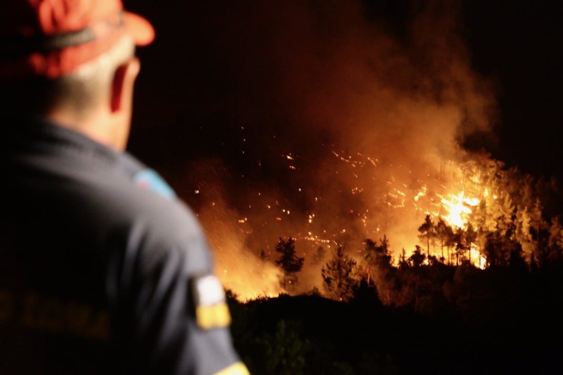 A firefighter watches as a wildfire burns on the island of Rhodes. Large fires have broken out throughout Greece, which has been suffering a prolonged drought. Photo: dpa A firefighter watches as a wildfire burns on the island of Rhodes. Large fires have broken out throughout Greece, which has been suffering a prolonged drought. Photo: dpa