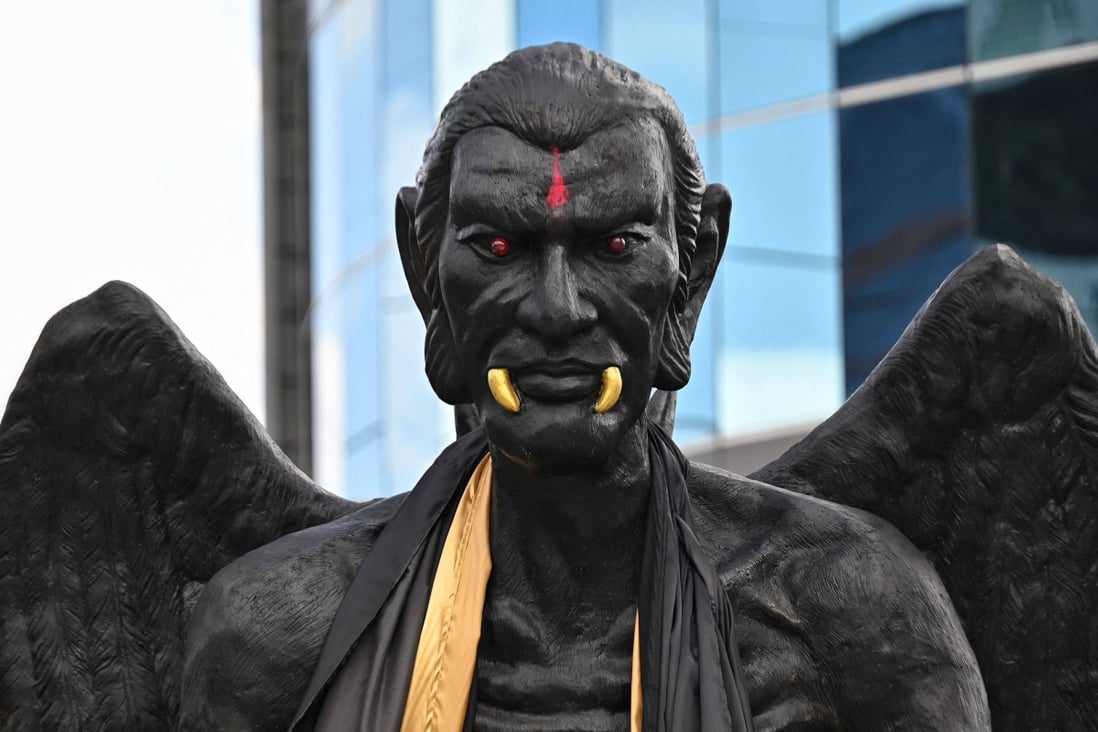 A giant statue of the deity Kru Kai Kaew glares down on a busy Bangkok street. Photo: AFP