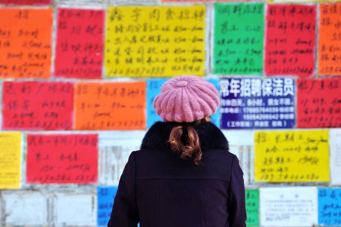 A woman studies a wall full of job adverts in Qingdao city. Photo: Reuters