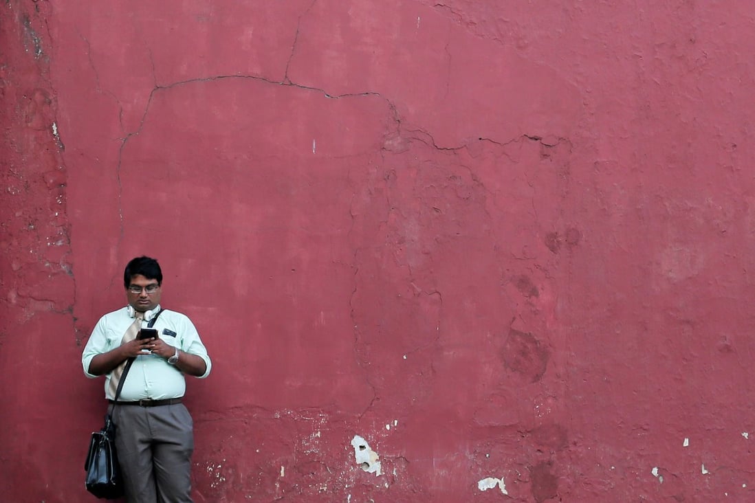 A man in Colombo, Sri Lanka, uses his mobile phone. Beijing is actively exporting its internet successes, empowering businesses to transact online through the same tools developed in China. Photo: Reuters