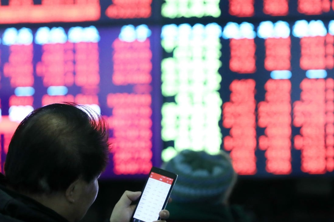 An investor checks his smartphone at trading hall in Shanghai on February 25, 2019. Photo: Xinhua