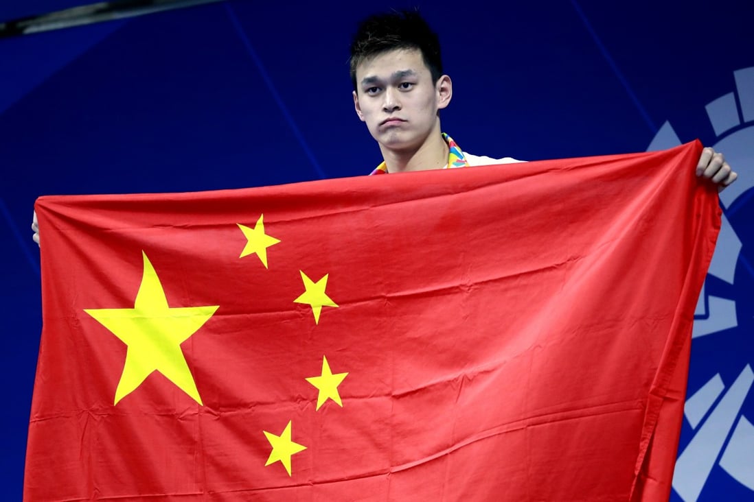 Sun Yang stands on the podium holding his national flag after receiving his gold medal in the men’s 400m freestyle final at the 18th Asian Games in Jakarta in 2018. Photo: AP