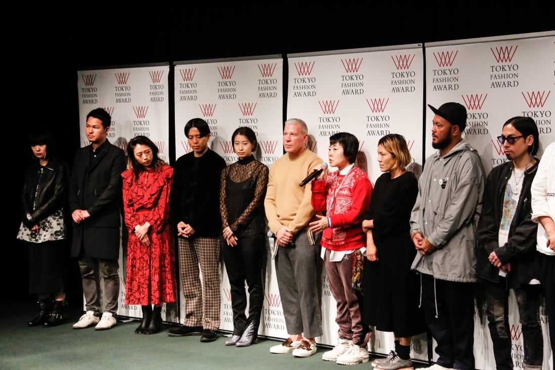 Akiko Shinoda (in red sweater) flanked by Nick Wooster (on her right) with Japanese designers at Tokyo Fashion Week.