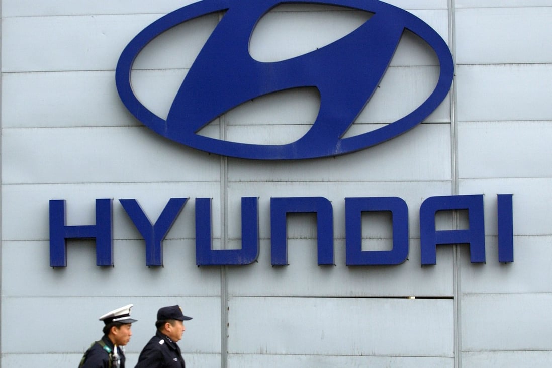 In this file photo taken on April 19, 2006, police officers walk past a Hyundai logo displayed in front of the Seoul headquarters pf South Korea’s largest carmaker. Photo: Jung Yeon-je/AFP