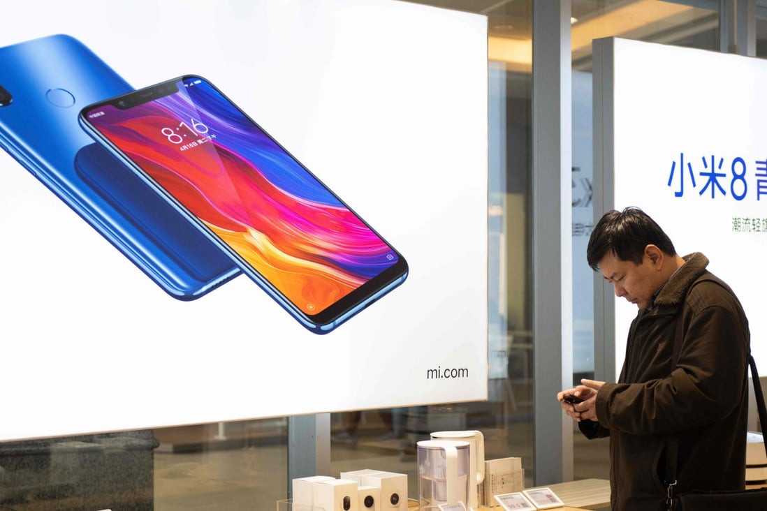 A customer studies a mobile phone in a Xiaomi store in Beijing. Photo: Agence France-Presse