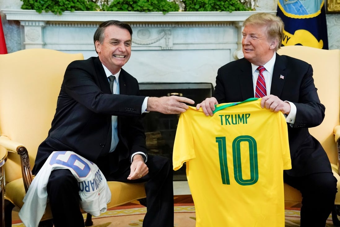 Brazil's President Jair Bolsonaro presents a Brazil national soccer team jersey to US President Donald Trump. Photo: Reuters