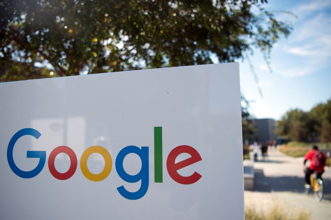 A man rides a bike past a Google sign and logo at the Googleplex in Menlo Park, California. Photo: AFP
