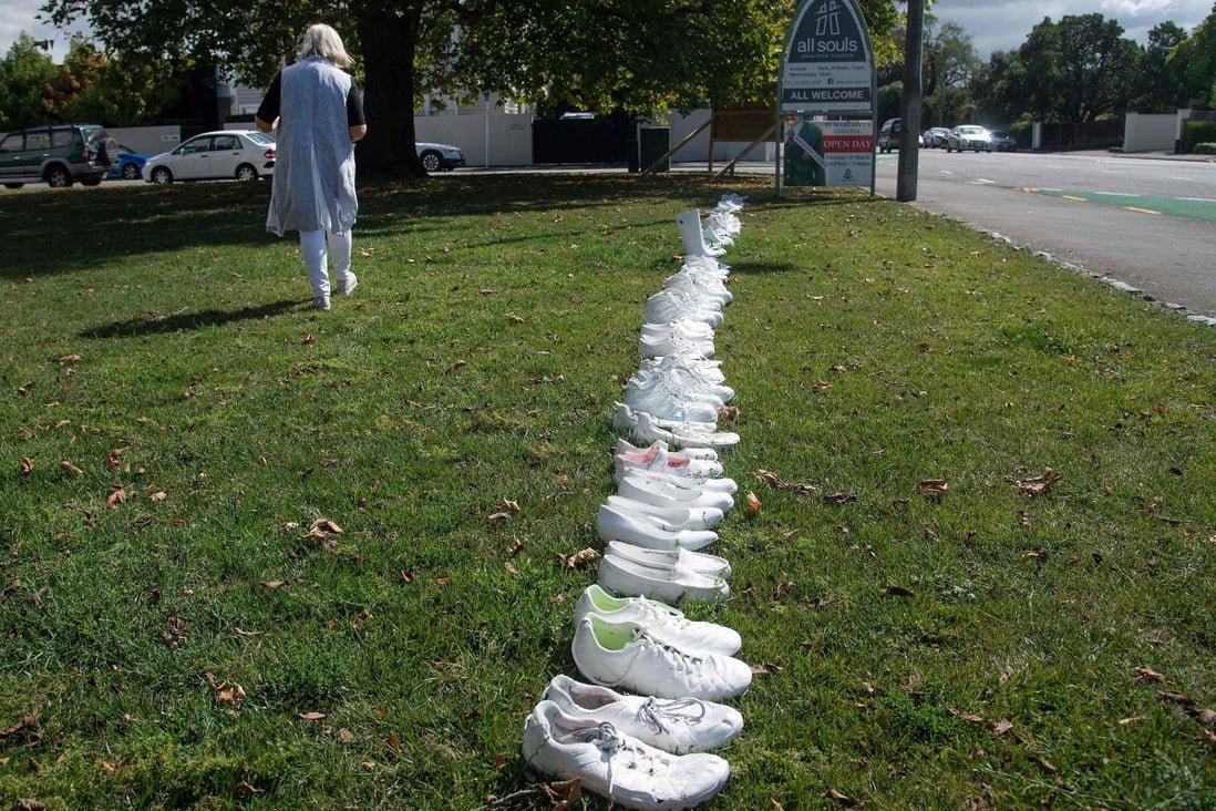 A church staff member walks past 50 pairs of shoes placed outside the All Souls Church in Christchurch on March 19, representing the 50 people gunned down at two mosques in the city four days before. Photo: AFP