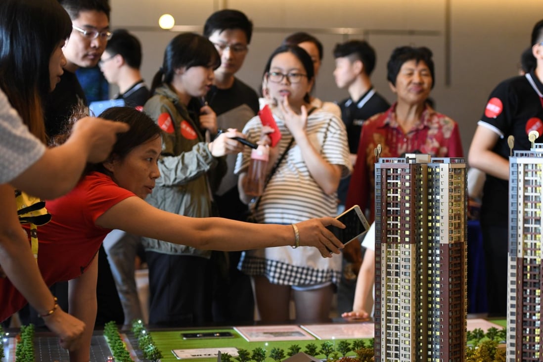 People check out the model of a residential compound by China Vanke in Dongguan, Guangdong province, China on October 2, 2018. Photo: Reuters
