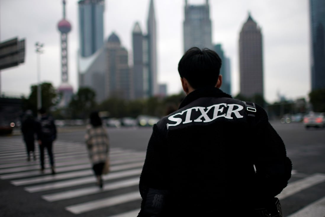 A man walks through the Lujiazui financial district in Pudong, Shanghai. China's GDP growth slowed from 9.5 per cent in 2011 to 6.6 per cent in 2018. The slowdown can be blamed on a variety of factors, but the first and probably most important is that China is getting older. Photo: Reuters