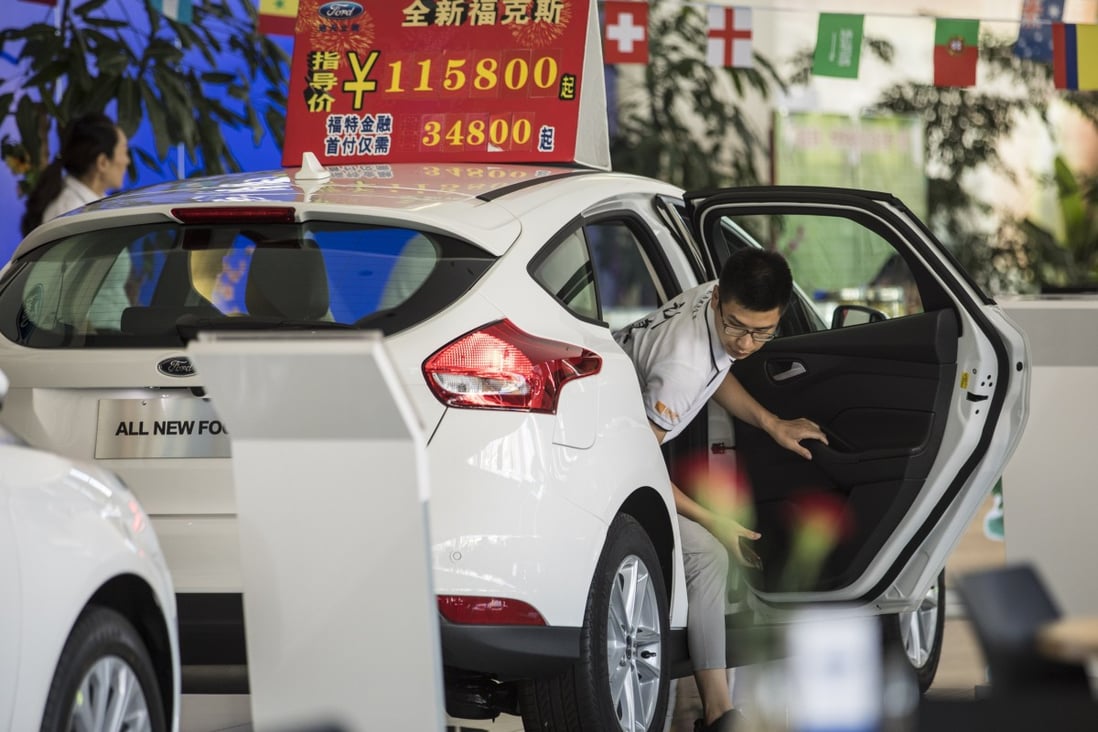 A customer steps out of a Ford Motor Co. vehicle on display at a Ford showroom in Shanghai, China, last year. Photo: Bloomberg