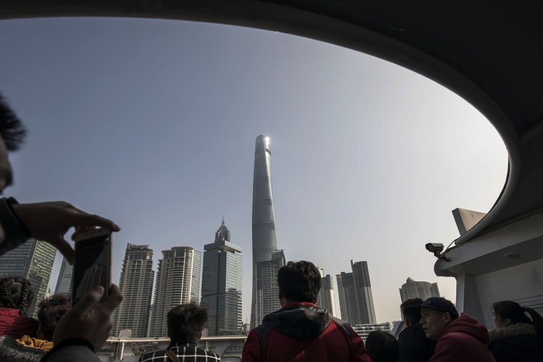 Tourists on a ferry crossing the Huangpu River view the Shanghai Tower and other buildings in the Lujiazui financial district in Shanghai, China. Photo: Bloomberg