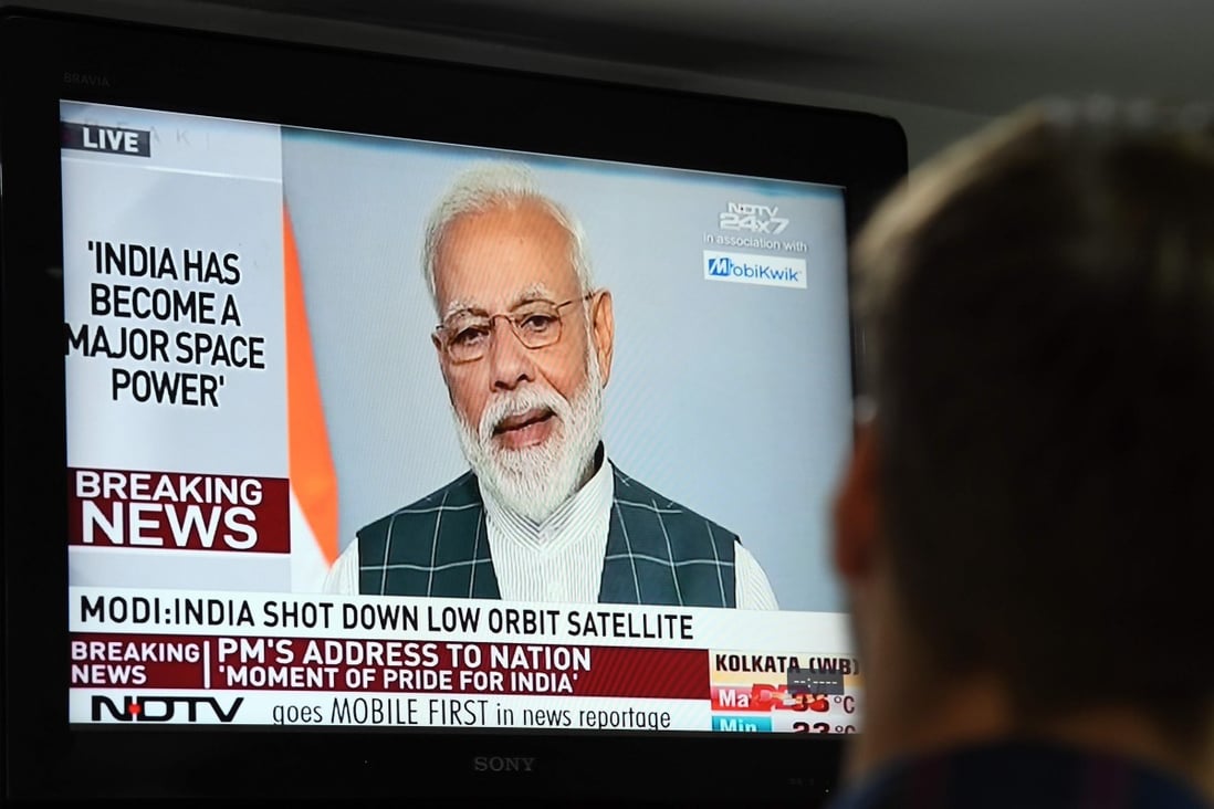 A man watches Indian Prime Minister Narendra Modi's address to the nation where he announced India had destroyed a low-orbiting satellite in a missile test. Photo: AFP