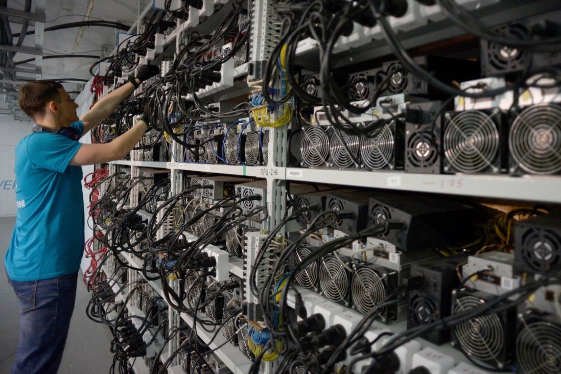 An employee inspects machines for the production of bitcoin and lightcoins. Photo: AFP