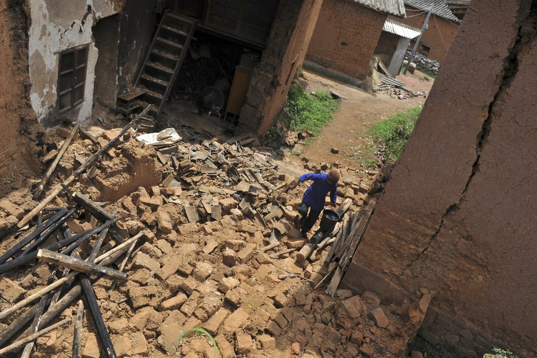 A woman walks on the debris of her collapsed house in the earthquake-hit Yao'an county, Yunnan province, on July 10, 2009. UBS said the earthquake prevented it from verifying the existence of China Forestry Holdings’ assets. Photo: Reuters/China Daily