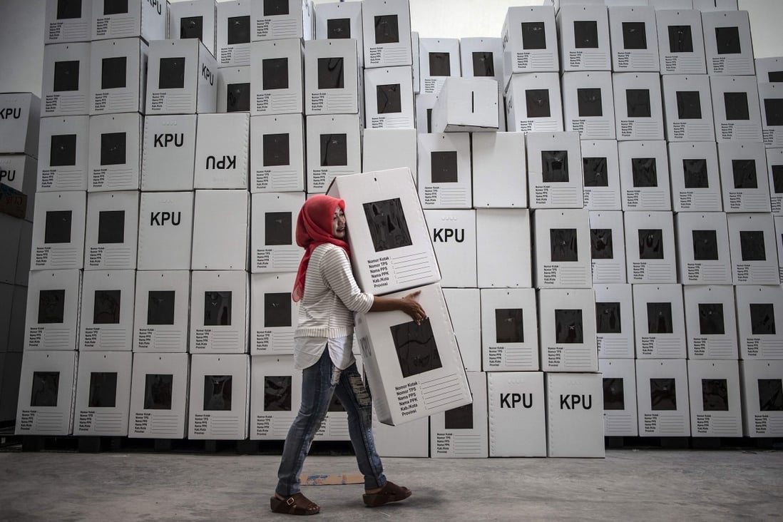 An Indonesian election commission worker arranging ballot boxes in Surabaya. Photo: AFP