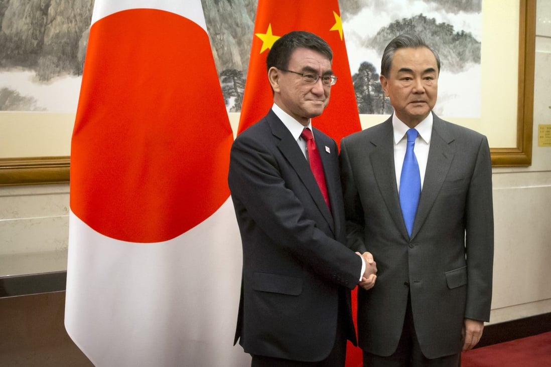 Japanese Foreign Minister Taro Kono, left, shakes hands with Chinese Foreign Minister Wang Yi in Beijing on Monday. Photo: AP