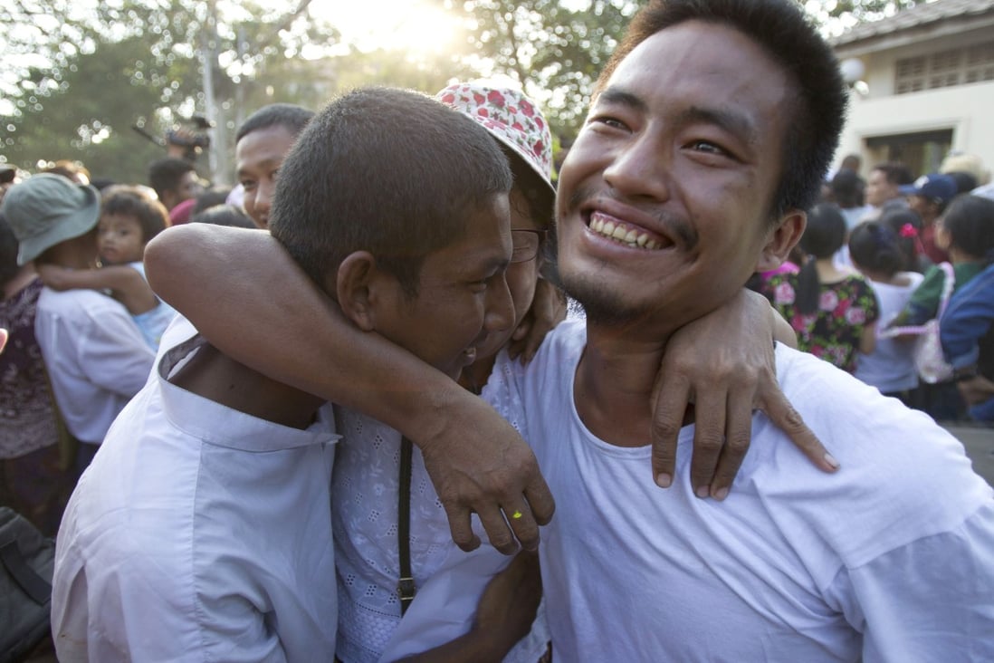 Two men celebrate with their mother after being released from Insein prison. Photo: AP Photo