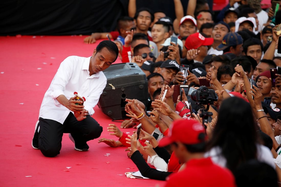 Indonesia's President Joko Widodo takes pictures with supporters during a campaign rally, on March 24. Photo: Reuters
