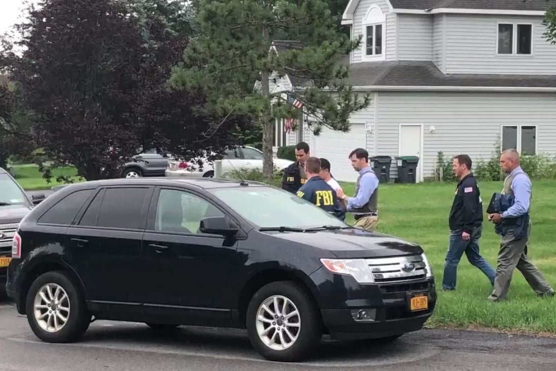 After a search of Xiaoqing Zheng's home in New York, FBI agents said they retrieved a passport showing five trips to China in the past two years. Photo: Jake Lahut via Twitter