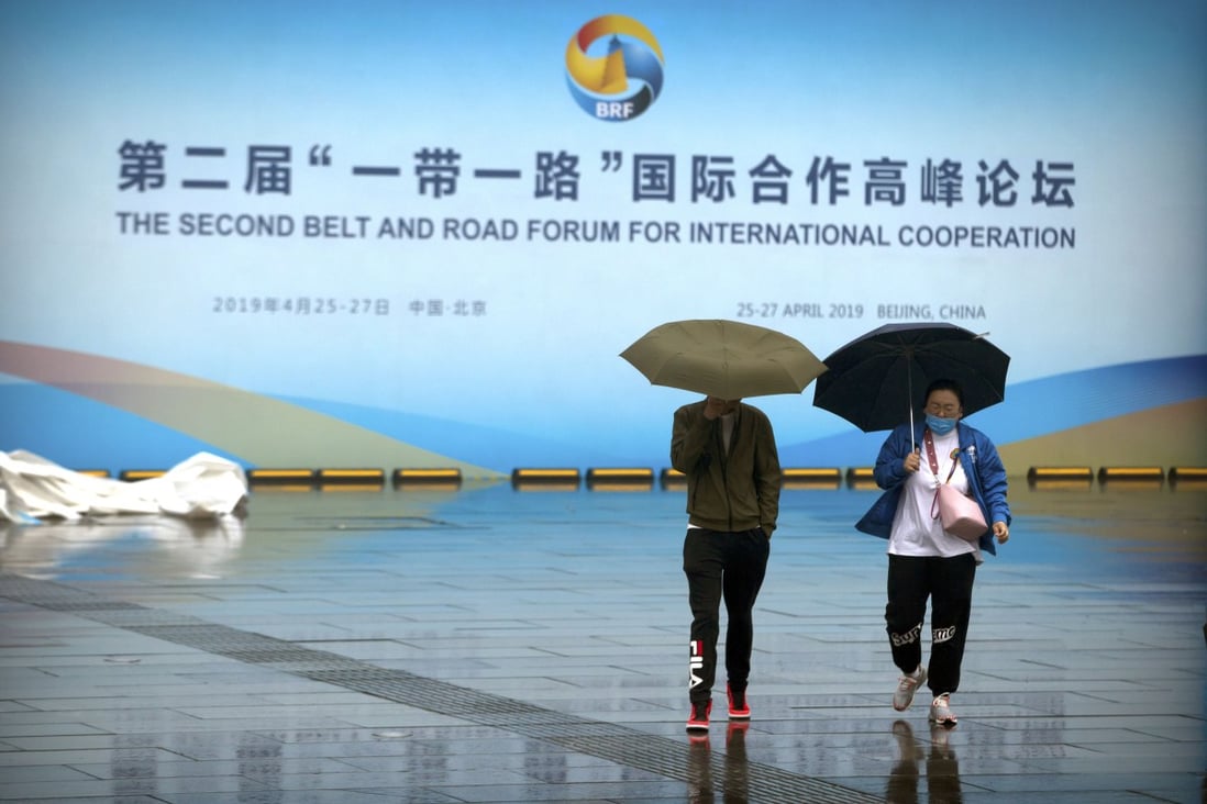 People carry umbrellas outside the Belt and Road Forum at the China National Convention Center in Beijing on Saturday. Photo: AP