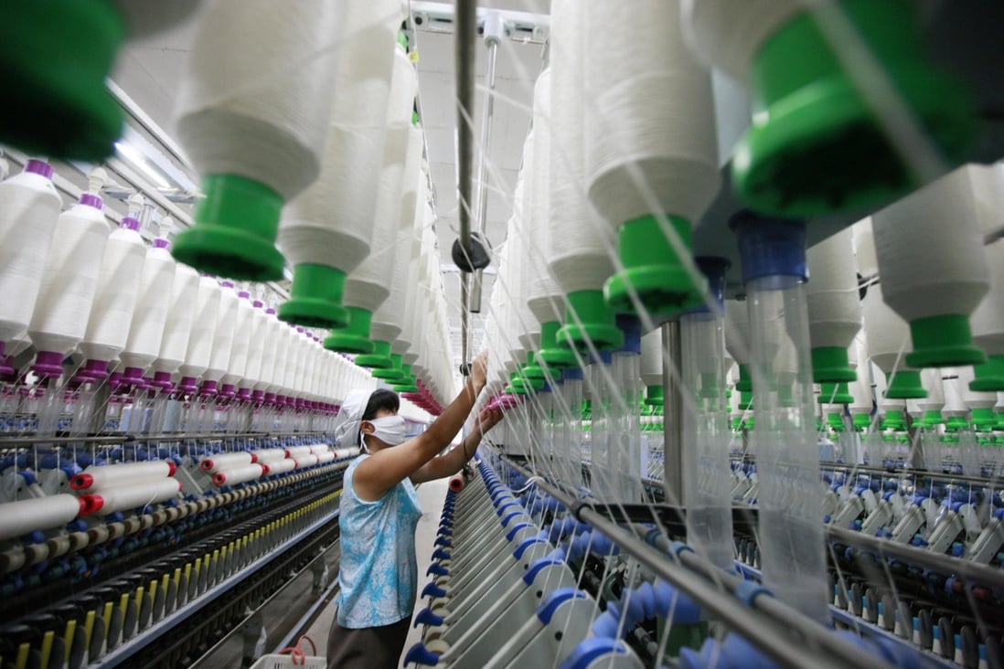 A worker operates machines for making yarn at a textile factory in Huaibei, east China's Anhui province. Photo: AFP