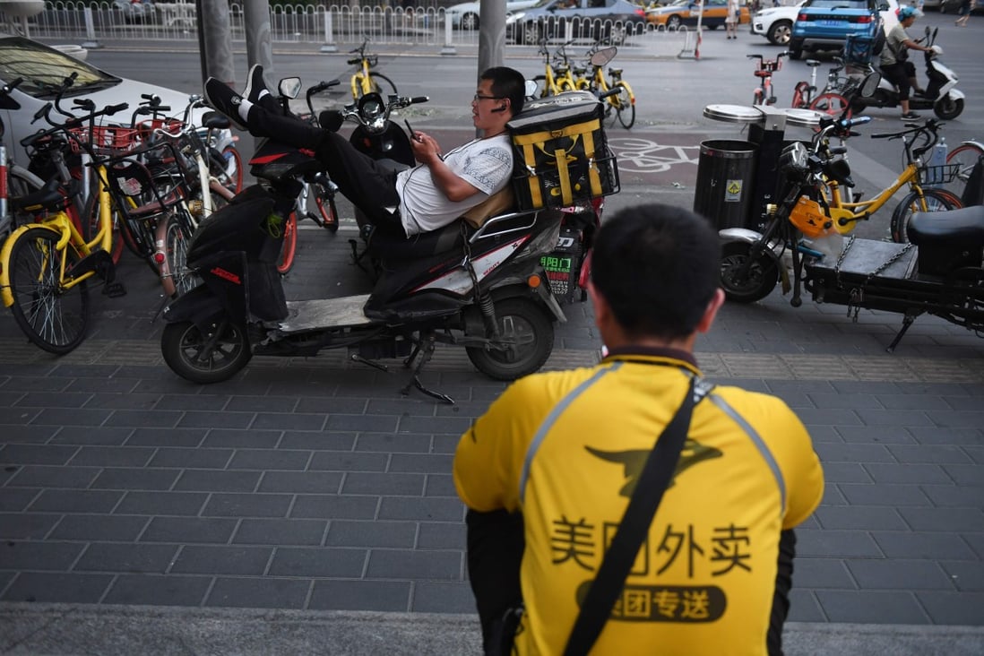 Meituan delivery riders wait for food delivery assignments in Beijing on June 26, 2018. Photo: AFP