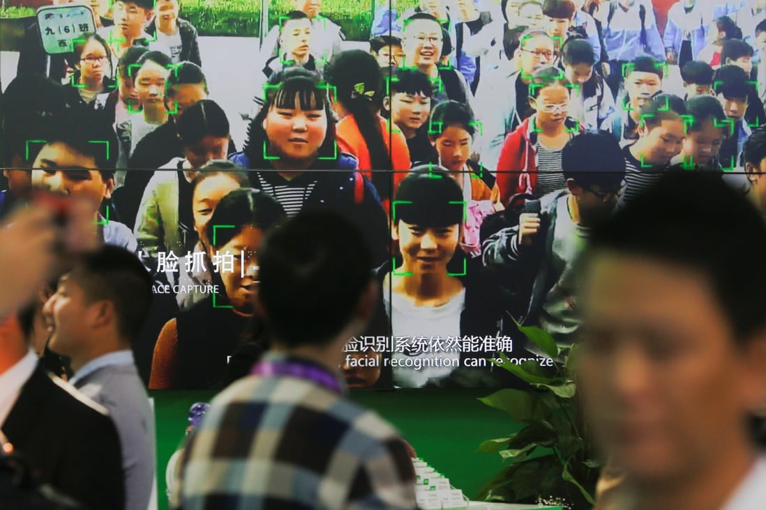 Visitors walk past a screen showing a demonstration of facial recognition software at the Security China 2018 exhibition on public safety and security in Beijing, China October 23, 2018. Photo: Reuters