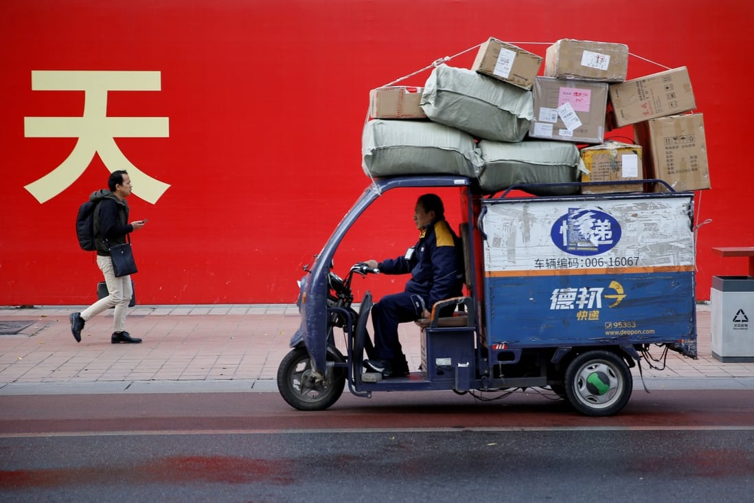 An electric delivery vehicle drives past a banner with a government slogan in Beijing. China is introducing stimulus measures to stabilise the financial system and help financially troubled local governments, but not to restart the economy. Photo: Reuters
