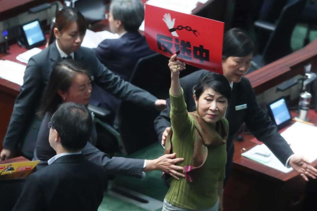 Lawmaker Claudia Mo is escorted from the Legislative Council chamber after accusing Chief Executive Carrie Lam of lying. Photo: Sam Tsang