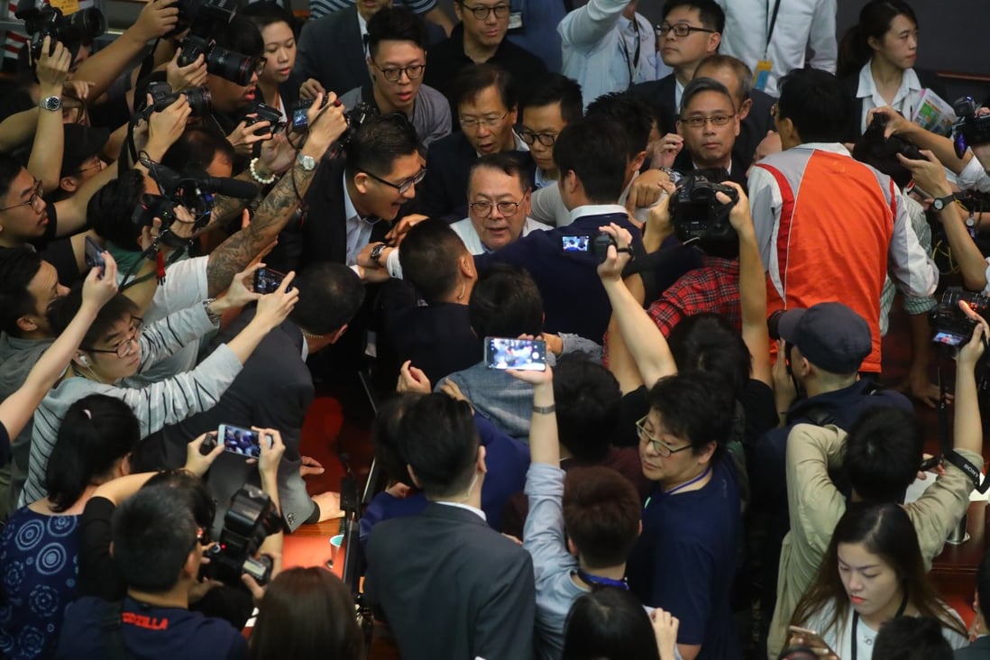 Legislator Abraham Razack is surrounded by lawmakers and the media in chaotic scenes inside the Legislative Council. Photo: Edmond So