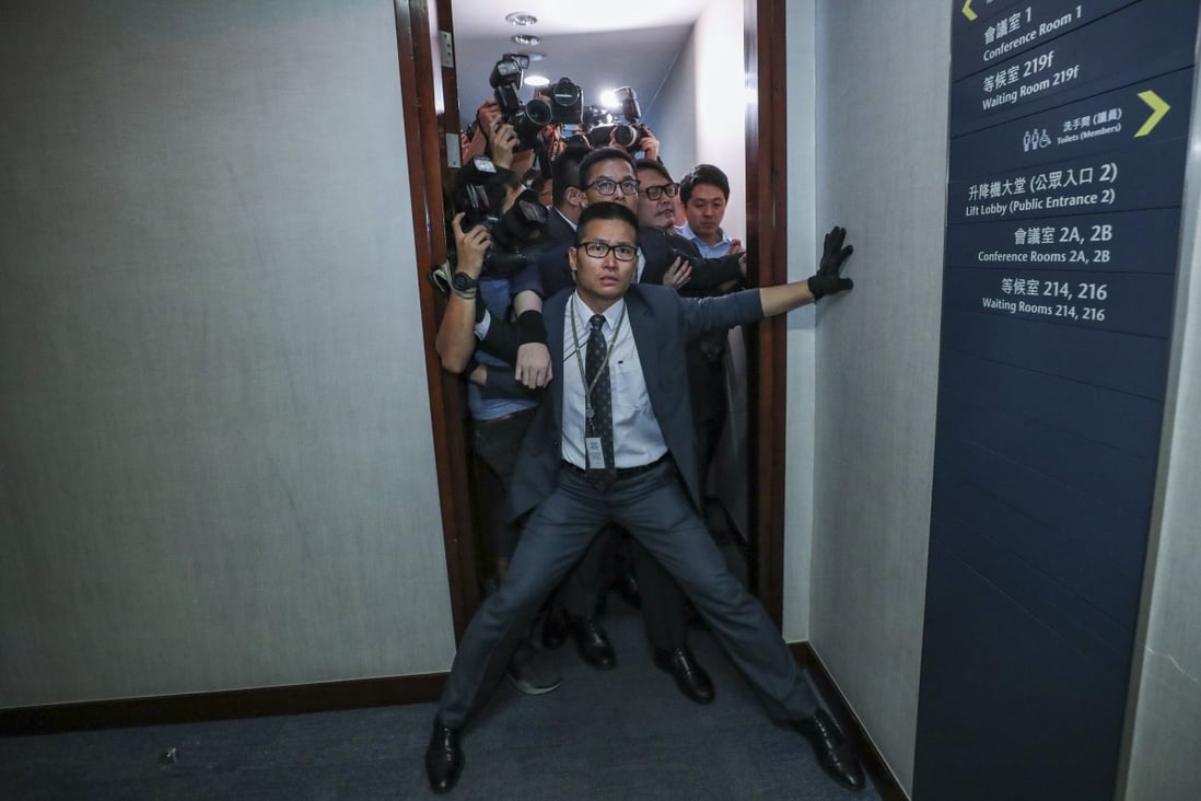 A security officer tries to stop reporters from entering the bills committee meeting. Photo: Sam Tsang