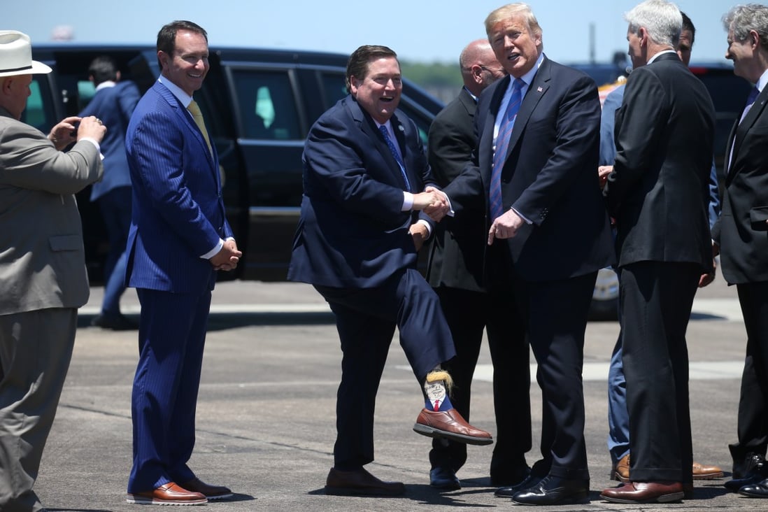 US President Donald Trump is greeted by Louisiana Lieutenant Governor Billy Nungesser showing off his socks as the president arrives in Lake Charles, Louisiana, May 14, 2019. Photo: Reuters