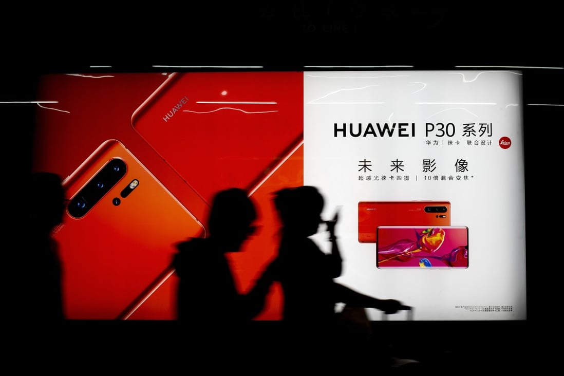 Commuters walk by an advert for the the new Huawei P30 smartphone inside a subway station in Beijing Monday, May 13, 2019. Photo: AP