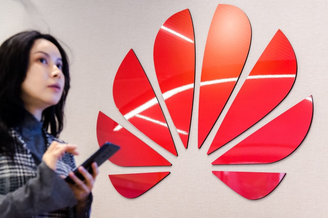 An attendee uses a smartphone as the Huawei Technologies logo sits on a wall at the company's Cyber Security Transparency Centre in Brussels, Belgium, on Tuesday, May 21, 2019. Photo: Bloomberg