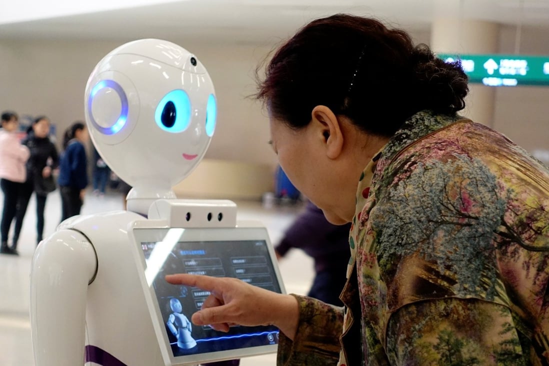 A woman touches a screen on a robot developed by iFlytek at the People's Liberation Army General Hospital in Beijing. Photo: Reuters