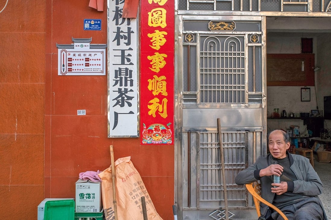 Cui Dongliang, at his tea shop in Yangqiao, Zhejiang province, in China. Next to the door is a sign that indicates his social credit score, which he himself upgraded to five stars using stick­ers. Photo: Gilles Sabrié for The Daily Telegraph Magazine
