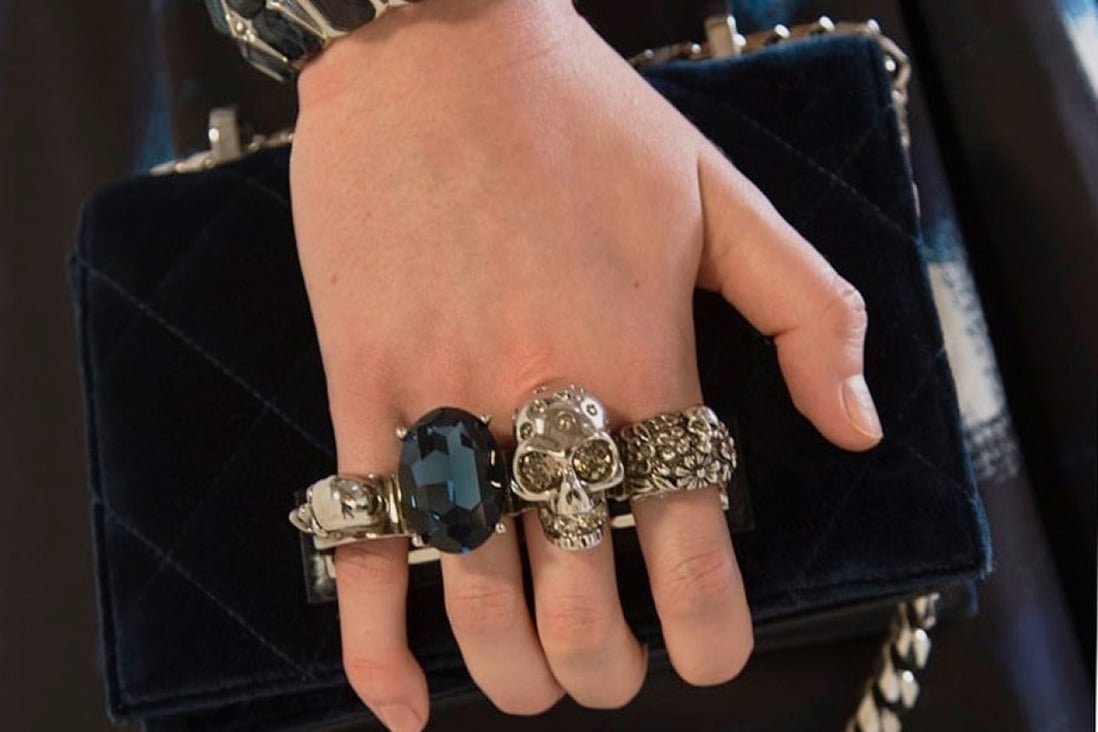Logos in luxury goods seem to become smaller as the price rises, as seen in this small jewelled Alexander McQueen clutch in night-blue velvet matelassé with silver hardware.