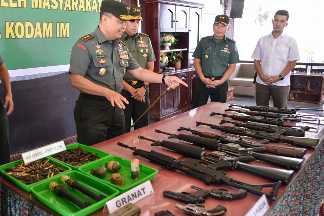 Military officials inspect weapons confiscated from ex-Aceh rebels in Banda Aceh. Photo: AFP