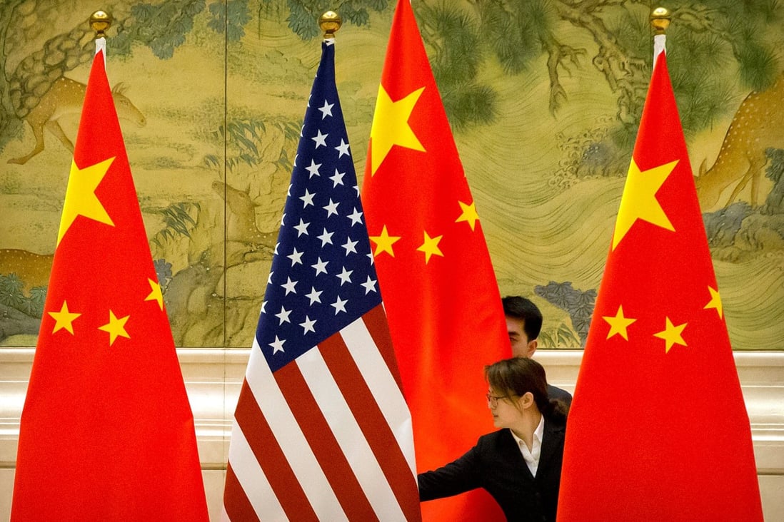 Staff adjust US and Chinese flags before the opening session of trade negotiations between US and Chinese trade representatives in Beijing in February. Photo: Reuters