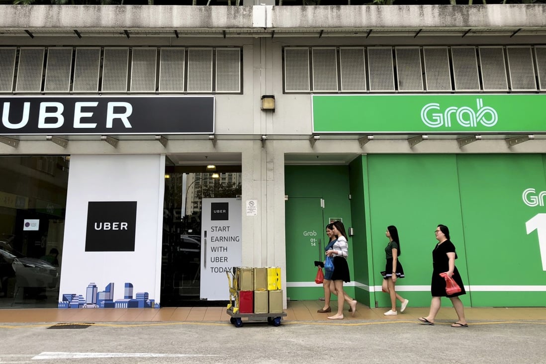 People walk past the offices of ride-hailing apps in Singapore. A start-up from the city state hopes to launch the same technology in West African nations. Photo: AP