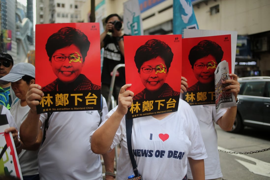 Protesters cover their faces with posters of Chief Executive Carrie Lam during the march from Causeway Bay to the government headquarters in Admiralty. Photo: Winson Wong