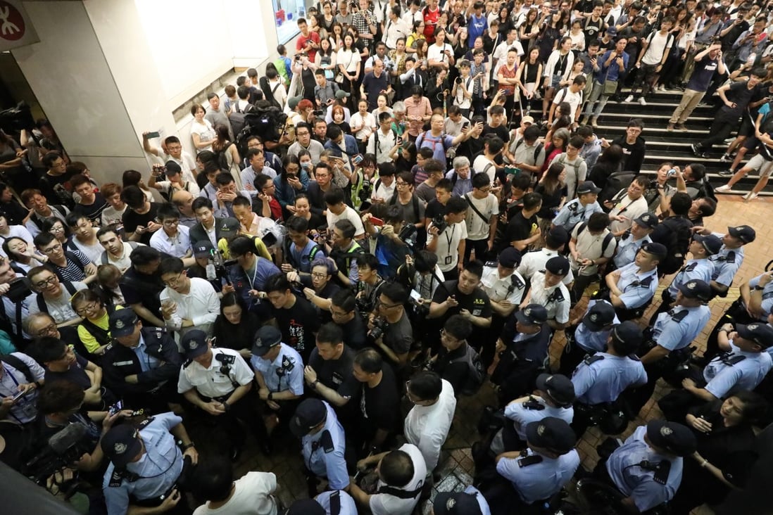 Residents and legislators surround police at an MTR station to question why they are stopping and searching people on Tuesday night. Photo: Dickson Lee
