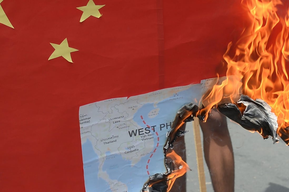 Activists burn a mock Chinese flag with a map of the South China Sea during a protest in front of the Chinese consulate in Manila. Photo: AFP