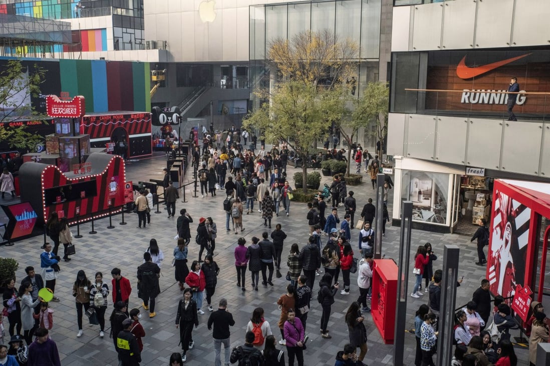 Shoppers and pedestrians walk past stores in the Sanlitun area of Beijing. Retail sales, a key indicator of consumer demand in China, grew by 8.6 per cent, up from April’s reading of 7.2 per cent, which was the lowest rate of growth since May 2003. Photo: Bloomberg