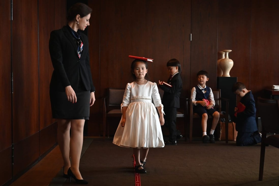 Miona Milakov guides Zoey Zhang on how to walk during an etiquette and manners class in central Shanghai. Photo: AFP